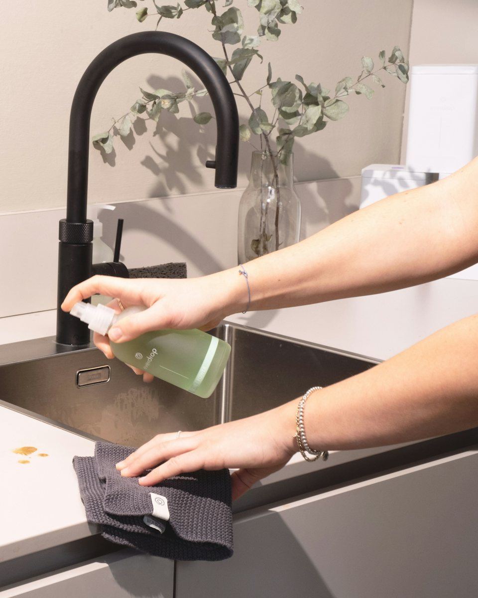 Northstar cleaner spraying and wiping a kitchen sink in a Toronto condo